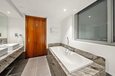 a bathroom with a large tub and two sinks at Elegant 2BR with Burj Views, Pool, Gym, and Quick Metro Access in Dubai