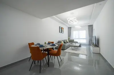 a white living room with a table and chairs at Dubai Marina - 1 BHK Unique Apartment in Dubai