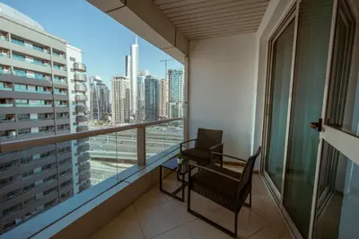 a balcony with a chair and a view of the city at Dubai Marina - 1 BHK Unique Apartment in Dubai