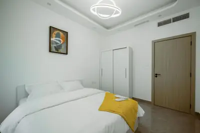 a bedroom with a white bed with a yellow blanket on it at Dubai Marina - 1 BHK Unique Apartment in Dubai
