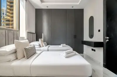 two large white beds in a room with a window at GuestReady - Mesmerizing Marina views at Iris Blue in Dubai