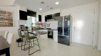 a kitchen with a glass table and a refrigerator at April OFFER Huge 1BKH 4people & high floor in Dubai
