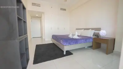 a bedroom with a purple bed and a desk at April OFFER Huge 1BKH 4people & high floor in Dubai