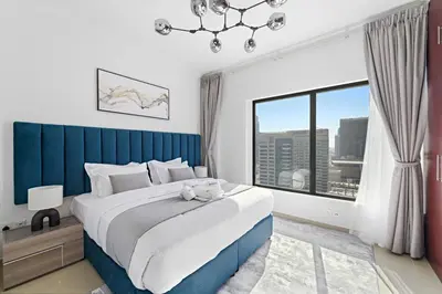 a bedroom with a large bed and a large window at Time Place Near Metro and Mall in Dubai