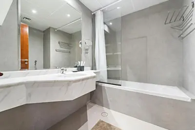 a bathroom with a large sink and a tub at Time Place Near Metro and Mall in Dubai