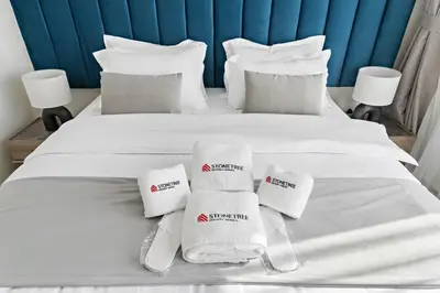 a white bed with towels and pillows on it at Time Place Near Metro and Mall in Dubai
