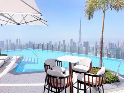 a table and chairs next to a swimming pool at Iconic 1Bedroom Duplex with Skyline Views Near Downtown Dubai & Burj Khalifa in Dubai