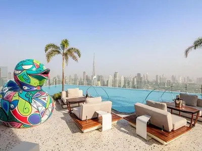 a swimming pool with chairs and tables and a pool at Iconic 1Bedroom Duplex with Skyline Views Near Downtown Dubai & Burj Khalifa in Dubai