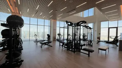 a gym with several treadmills and machines in a room with windows at Iconic 1Bedroom Duplex with Skyline Views Near Downtown Dubai & Burj Khalifa in Dubai