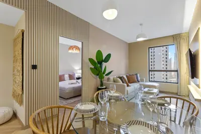 a living room with a glass table and chairs at Beachside Home on JBR Walk with modern interiors in Dubai