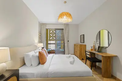 a bedroom with a bed and a desk and a television at Beachside Home on JBR Walk with modern interiors in Dubai