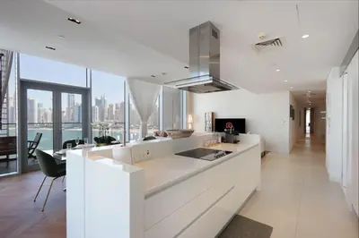 a white kitchen with a view of the city at Livbnb - Ain Dubai Panorama, 3BR with Maid's Room in Dubai