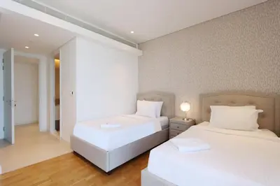 two beds in a room with white walls and wood floors at Livbnb - Ain Dubai Panorama, 3BR with Maid's Room in Dubai