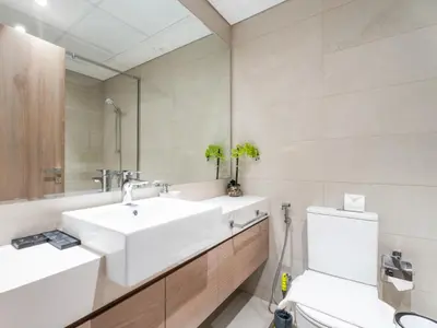 a bathroom with a white sink and a toilet at Cozy Stay 1BR in Azizi Pearl in Dubai