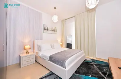 a white bedroom with a bed and a window at Blue Breeze - Elegant 3BR Apt with Panoramic Marina Views in JBR in Dubai