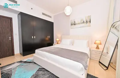 a bedroom with a white bed and a black cabinet at Blue Breeze - Elegant 3BR Apt with Panoramic Marina Views in JBR in Dubai