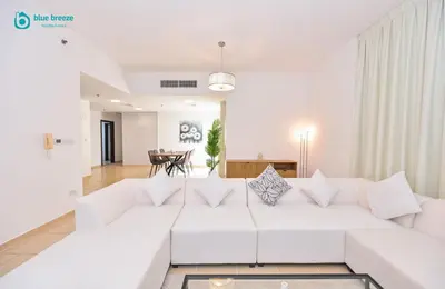 a white living room with a white couch at Blue Breeze - Elegant 3BR Apt with Panoramic Marina Views in JBR in Dubai