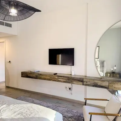 a living room with a tv and a mirror at Lamtara 3 MJL in Dubai