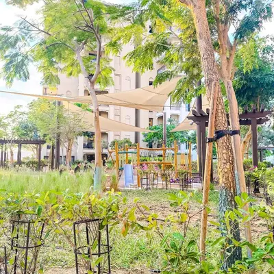 a garden with a table and chairs and trees at Lamtara 3 MJL in Dubai