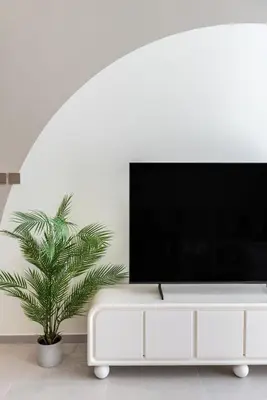 a living room with a tv and a plant at The Smart Concierge - Signature Grande in Dubai