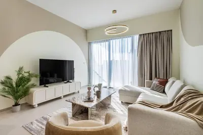 a living room with a couch and a tv at The Smart Concierge - Signature Grande in Dubai