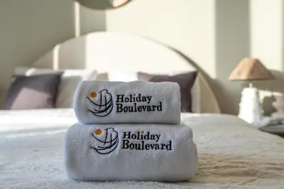 three towels stacked on top of a bed at BLVD - Steps from Dubai mall and Dancing Fountain in Dubai