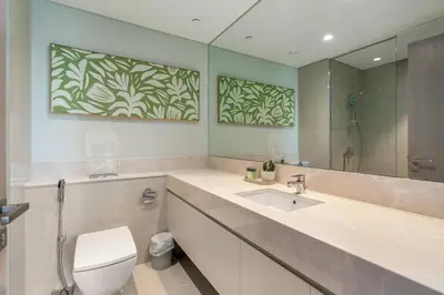 a bathroom with a sink and a toilet and a mirror at BLVD - Steps from Dubai mall and Dancing Fountain in Dubai