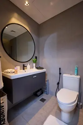 a bathroom with a toilet and a sink and a mirror at Full Burj Khalifa & Canal View I 7 Mins to Dubai Mall I Exclusive 2BHK For Up to 6 People in Dubai