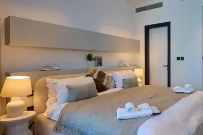 a bedroom with a large bed with towels on it at Full Burj Khalifa & Canal View I 7 Mins to Dubai Mall I Exclusive 2BHK For Up to 6 People in Dubai