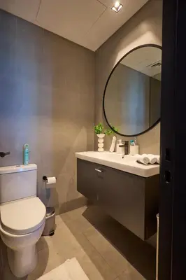 a bathroom with a toilet and a mirror at Full Burj Khalifa & Canal View I 7 Mins to Dubai Mall I Exclusive 2BHK For Up to 6 People in Dubai