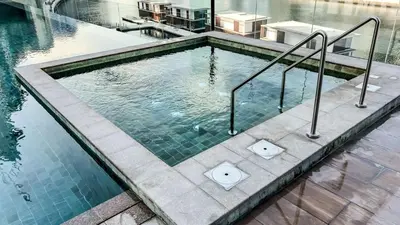 a swimming pool with metal rails in a building at Full Burj Khalifa & Canal View I 7 Mins to Dubai Mall I Exclusive 2BHK For Up to 6 People in Dubai