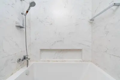 a white bathroom with a shower with a tub at Holiday Boulevard - Luxury 3BR Penthouse with Burj Khalifa and Creek Views in Dubai