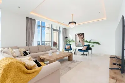 a living room with a couch and a tv at Holiday Boulevard - Luxury 3BR Penthouse with Burj Khalifa and Creek Views in Dubai