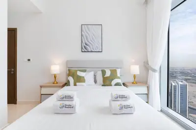 a bedroom with a white bed with a window at Holiday Boulevard - Luxury 3BR Penthouse with Burj Khalifa and Creek Views in Dubai