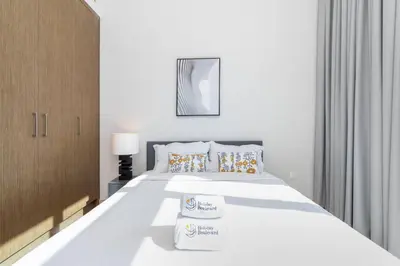 a bedroom with a white bed with two towels on it at Holiday Boulevard - Luxury 3BR Penthouse with Burj Khalifa and Creek Views in Dubai