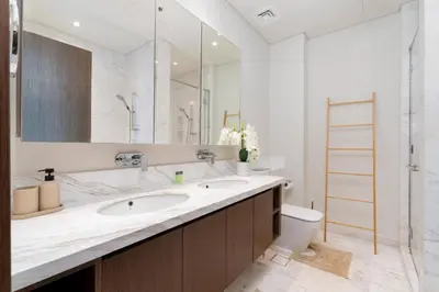 a bathroom with a sink and a toilet and a mirror at Holiday Boulevard - Luxury 3BR Penthouse with Burj Khalifa and Creek Views in Dubai