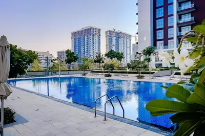 a large swimming pool in a city with tall buildings at Apartment in Dubai Hills Park Acacia A in Dubai