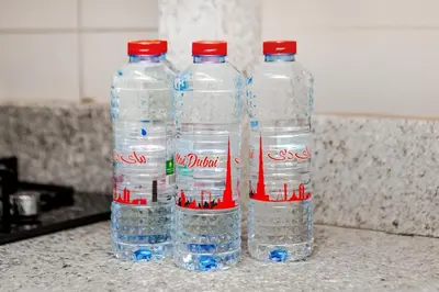 a group of four bottles of water on a counter at Apartment in Dubai Hills Park Acacia A in Dubai