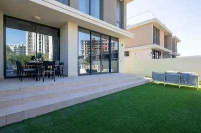 a house with a patio with a table and chairs at Frank Porter - Club Villas in Dubai