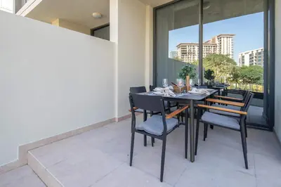 a dining room with a table and chairs on a balcony at Frank Porter - Club Villas in Dubai