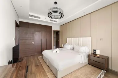 a bedroom with a large white bed and a wooden wall at Elegant 1BR with Panoramic Views on Burj Khalifa in Dubai