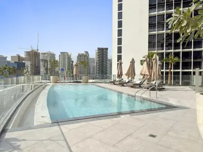 a swimming pool with chairs and umbrellas on a building at Elegant 1BR with Panoramic Views on Burj Khalifa in Dubai