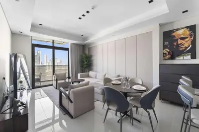 a living room with a couch and a table and chairs at Elegant 1BR with Panoramic Views on Burj Khalifa in Dubai