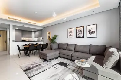 a living room with a couch and a table at Sky-High 2BR - Infinity Pool & Burj Khalifa Views in Dubai