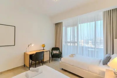 a hotel room with a bed and a desk and a window at Spacious l Opened View l Fits 4 in Dubai
