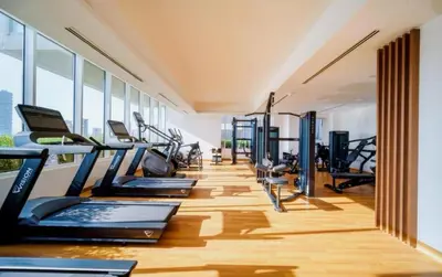 a gym with a row of treadmills and ellipticals at Spacious l Opened View l Fits 4 in Dubai