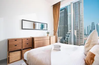 a bedroom with a white bed and a large window at FIRST CLASS 3BR Burj Khalifa & Fountain view in Dubai