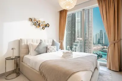 a bedroom with a large bed with a large window at FIRST CLASS 3BR Burj Khalifa & Fountain view in Dubai