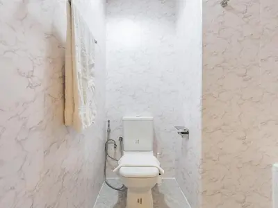 a bathroom with a white toilet in a white wall at The 'Mallorca' Condo - JBR Beachfront Stay in Dubai
