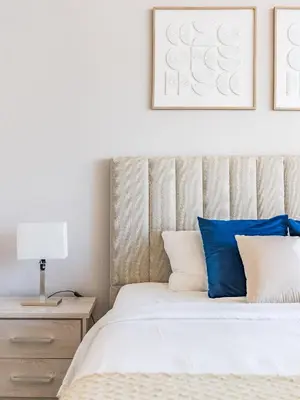 a bedroom with a white bed with blue pillows at The 'Mallorca' Condo - JBR Beachfront Stay in Dubai